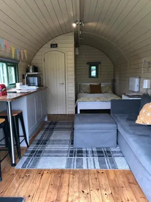 a living room with a couch and a bed in a room at Barnharrow Holiday Pods in Newton Stewart