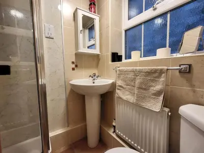 a bathroom with a sink and a toilet and a shower at Holly Cottage Grasmere in Grasmere