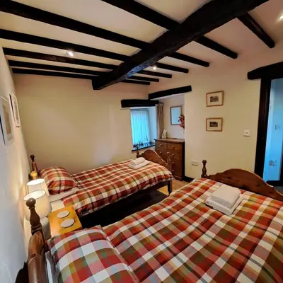 a bedroom with two beds in a room at Oakside Cottage Braithwaite in Braithwaite