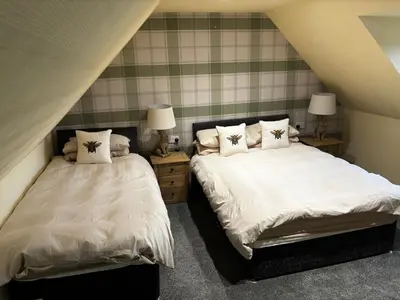 a bedroom with two beds and two lamps at The Bee Hive Hotel in Coylton