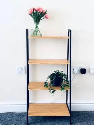 a shelf against a white wall with a vase of flowers at Linga House - 3 Bedrooms - Sleeps 5 in Frizington