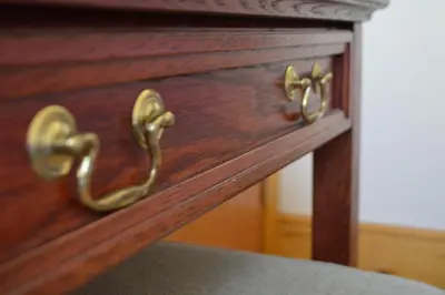 a wooden drawer with gold handles on a wooden cabinet at Sea Breeze Guest House in Douglas