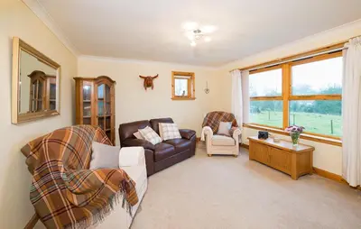 a living room with a couch and two chairs at Shellhill Cottage at Clauchan Holiday Cottages in Gatehouse of Fleet