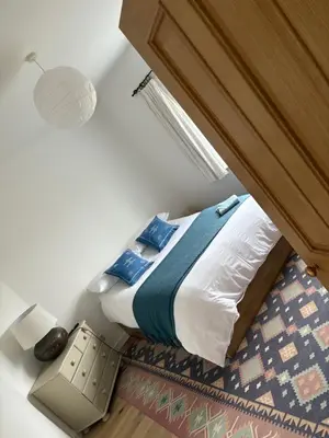 a bedroom with a bed with a wooden headboard at Mains of Greenlaw Cottage in Castle Douglas