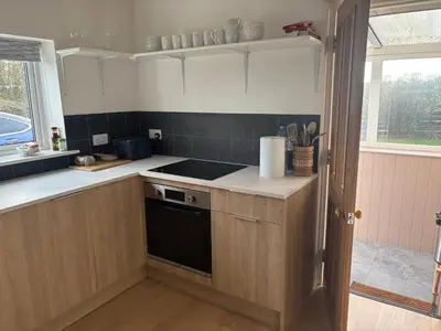 a kitchen with a sink and a stove at Mains of Greenlaw Cottage in Castle Douglas