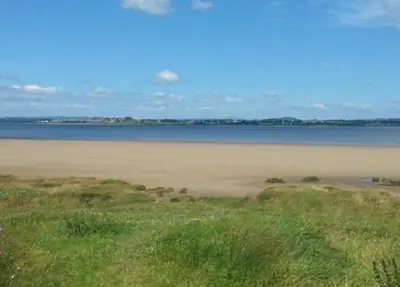 a beach with the ocean in the background at Cute Cottage in Historic Port Carlisle 12miles from M6 in Port Carlisle