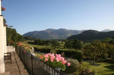 a balcony with flowers and mountains in the background at StoneyAcre in Keswick
