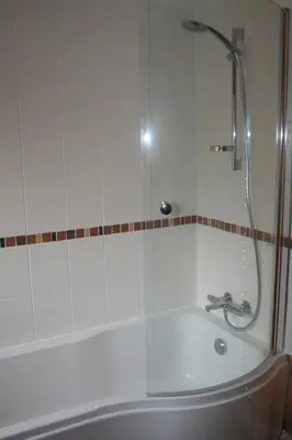 a bathroom with a bath tub with a shower at StoneyAcre in Keswick