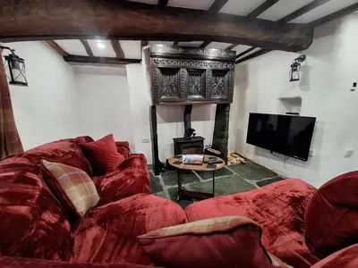 a living room with a red couch and a fireplace at Field House in Keswick
