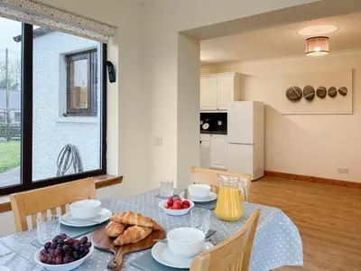 a dining room with a table with food on it at Shellhill Cottage in Kirkcudbright
