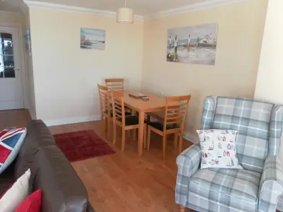 a living room with a couch and a table and chairs at isle of man holiday apartment in Douglas