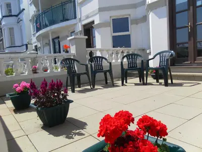 a group of chairs and flowers on a patio at isle of man holiday apartment in Douglas
