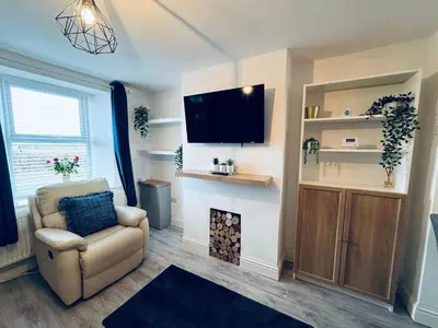 a living room with a chair and a fire place at Keekle Cottage - 2 Bedrooms - Sleeps 4 in Cleator Moor