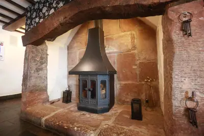 a fireplace in a stone wall with a stove at Lyons Manor House Caravan Park in Mawbray