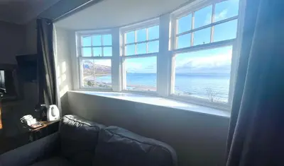 a large window with a view of the ocean at Burlington Guest House in Whiting Bay