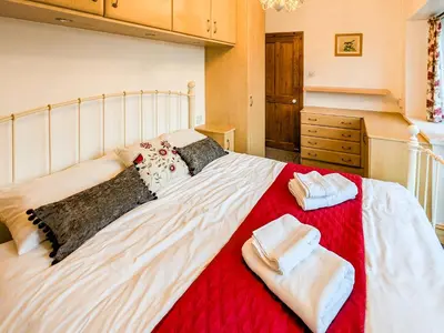 a bedroom with a large white bed with towels on it at Prior Bank in Canonbie