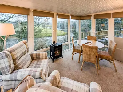 a screened in porch with a table and chairs and a stove at Prior Bank in Canonbie