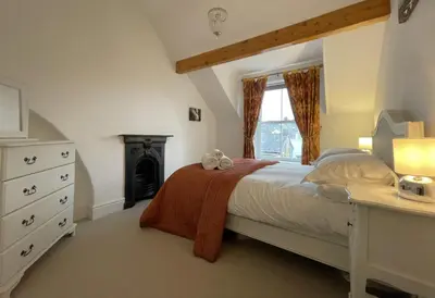 a bedroom with a bed and a desk and a window at 45 Eskin Street in Keswick