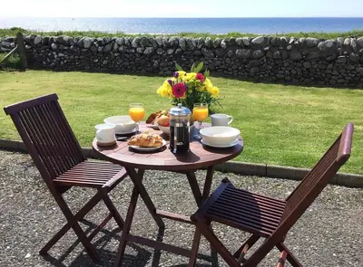 a table with a plate of food and flowers on it at Airyolland in Newton Stewart