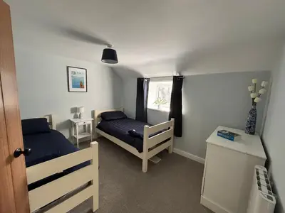 a bedroom with two beds and a window at The Barn in Ellonby