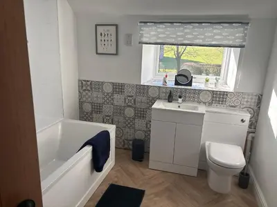 a bathroom with a tub sink and a toilet at The Barn in Ellonby