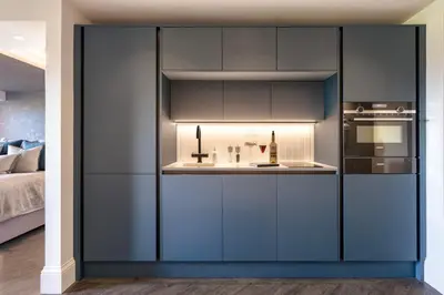 a kitchen with blue cabinets and a sink at The Retreat - Ridgestone in Penruddock