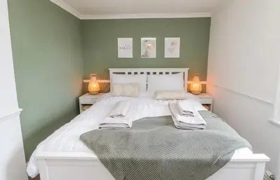 a bedroom with a bed with two lamps on it at Ploughmans Cottage in Brampton