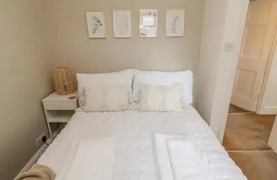 a bedroom with a bed with white sheets and pillows at Ploughmans Cottage in Brampton