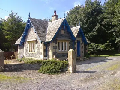 a small house with a blue roof at Ardwell House East Lodge in Stranraer