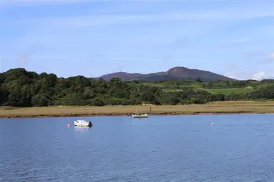 two boats on a lake with mountains in the background at Allonby Cottage in Kippford