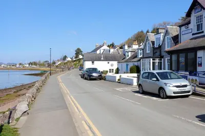 a street with cars parked on the side of the road at Allonby Cottage in Kippford