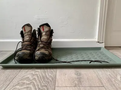 a pair of boots sitting on a mat next to a door at Lilac Cottage - Fell views & walks from the door in Cleator Moor