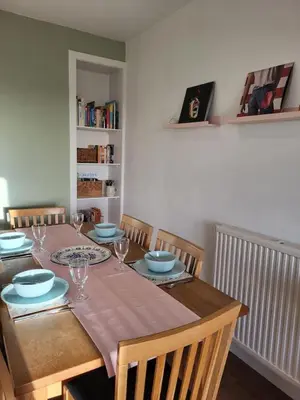 a dining room table with plates and glasses on it at The Wee House -Coorie Doon Stays in Troon