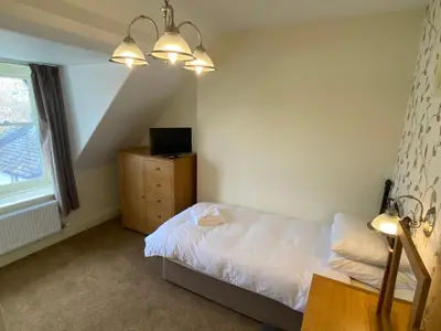 a bedroom with a bed and a dresser and lights at Berkeley House in Keswick