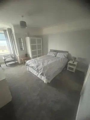 a bedroom with a bed and a chair and a window at Lakenhow in Seascale