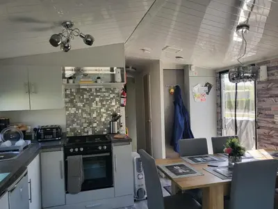 a kitchen with a table and a dining room at MLR at Craig Tara Bay View in Ayr