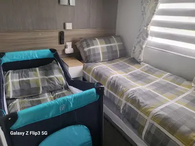 a small bedroom with two beds and a window at MLR at Craig Tara Bay View in Ayr