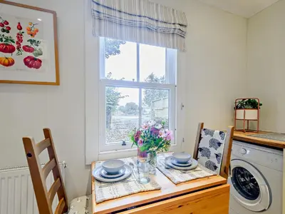 a kitchen with a table and a washing machine at 1 Bed in Maybole 93562 in Maybole