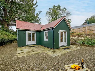 a green shed with a red roof and some oranges at 1 Bed in Maybole 93562 in Maybole