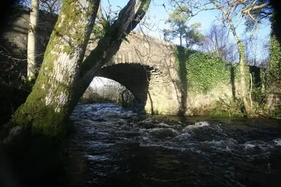 an old bridge over a stream with a river at The Hidden Mill, Historic Beauty Spot and spa in Castle Douglas