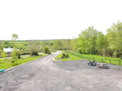 a road with two picnic tables on the side at Oaktree Cottage - 3 Bedrooms - Sleeps 6 in Frizington