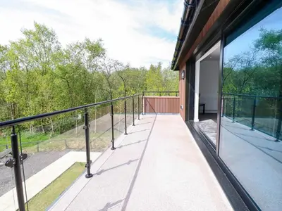 a balcony of a building with glass doors and trees at Oaktree Cottage - 3 Bedrooms - Sleeps 6 in Frizington
