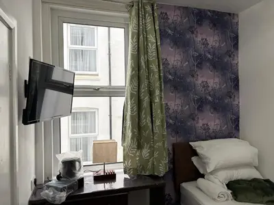 a bedroom with a bed and a window and a television at Athol House in Douglas