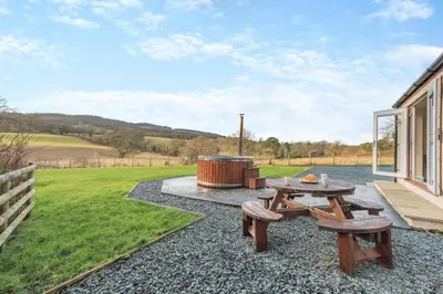 a patio with a barbecue and a table and benches at 3 Bed in Isel oc-i30816 in Sunderland