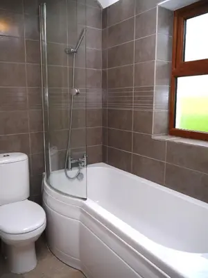 a bathroom with a tub and a toilet and a shower at Allanhead Cottage in Kirkcudbright