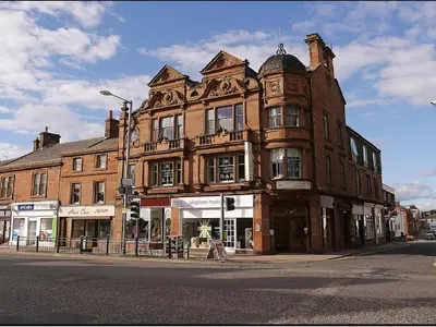 a large brick building on the corner of a street at Corner House Hotel in Annan