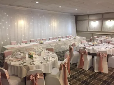 a banquet room with white tables and chairs with white tablesearcher at Corner House Hotel in Annan