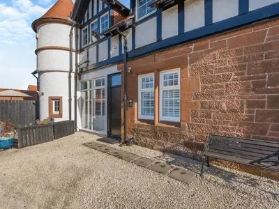 a brick building with a bench in front of it at Piersland Mews in Troon