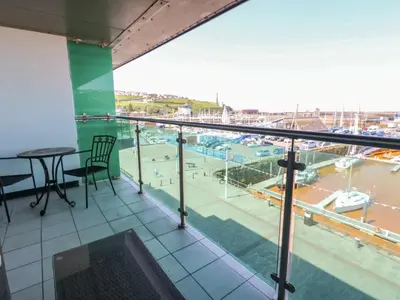 a balcony with a table and a view of a harbor at Pears Suite - 1 Bedroom - Sleeps 2 in Whitehaven