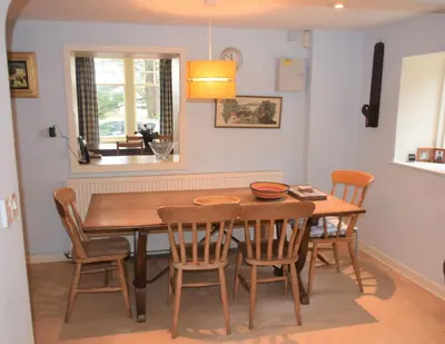 a dining room with a wooden table and chairs at Craigrathan in Kippford